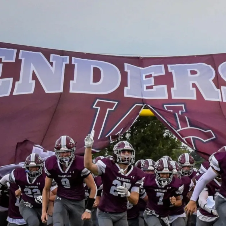 Henderson school football team taking the field in custom uniforms