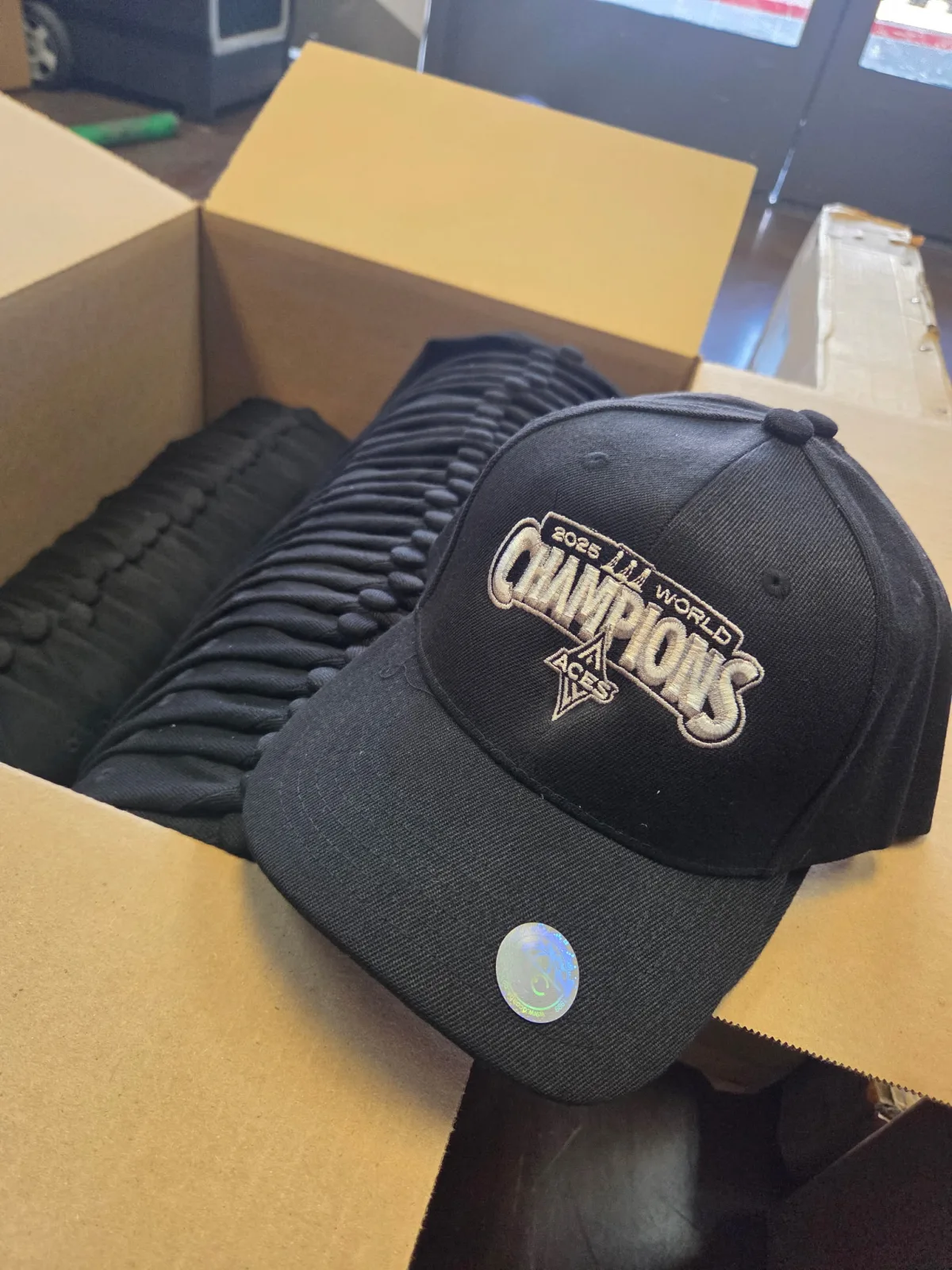 Box of custom embroidered World Champions caps ready for delivery